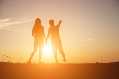  bir adam ve birlikte yürüyen birbirleri ile elele kadın silüeti.