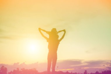 Anne oğlunu açık havada, günbatımı, siluet kavramı teşvik