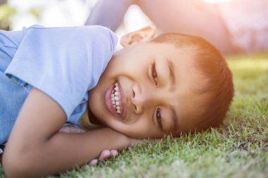 Mutlu melez erkek çocuk gülümseyen zevk yaşam kabul. Doğa, park veya açık havada Genç çocuk portresi. Mutlu bir aile veya başarılı evlat edinme veya ebeveynlik kavramı.