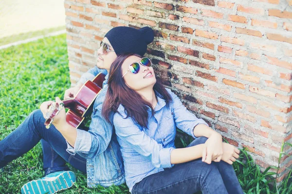 Hipster Uomo Suonare Chitarra Sua Ragazza All Aperto Contro Muro — Foto Stock