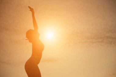 Güzel bir arka plan için dua eden bir kadın silueti.