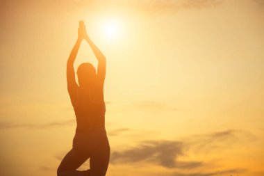 Güzel bir arka plan için dua eden bir kadın silueti.