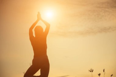 Güzel bir arka plan için dua eden bir kadın silueti.