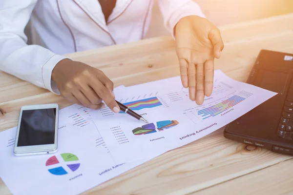 Hands of Businessman working on Laptop Computer with Data Charts