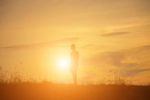 Silhouette of woman praying over beautiful sky background