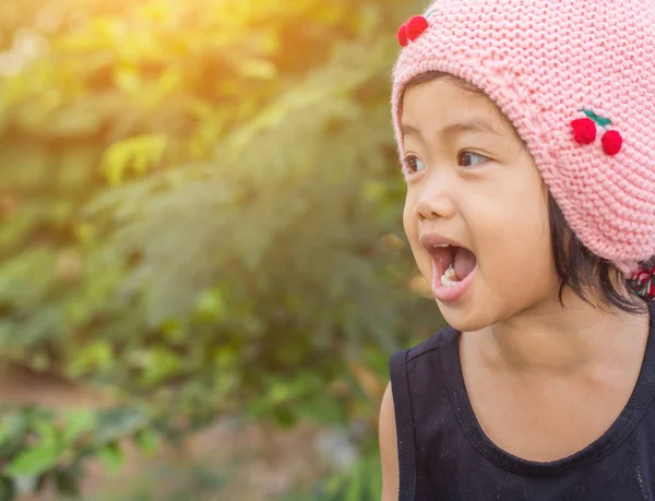 Mor çiçek alan güneş gün arasında duran küçük şirin Asyalı kız. Doğa ile zevk özgürlük.
