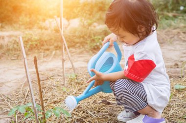 Küçük kız ağaç sulama pot ile sulama