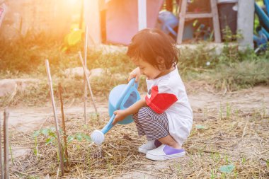 Küçük kız ağaç sulama pot ile sulama