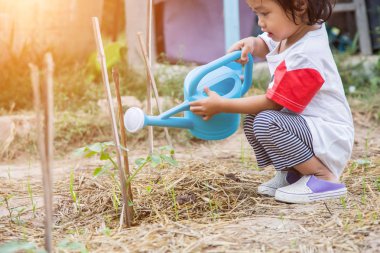 Küçük kız ağaç sulama pot ile sulama