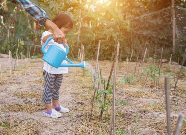 Küçük kız ağaç sulama pot ile sulama