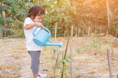 Küçük kız ağaç sulama pot ile sulama