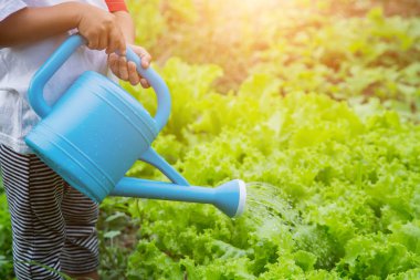 Küçük kız ağaç sulama pot ile sulama