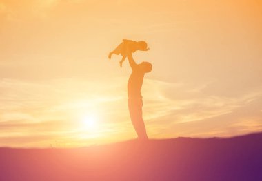 Baba ve küçük kızı günbatımında yürüyüş siluetleri