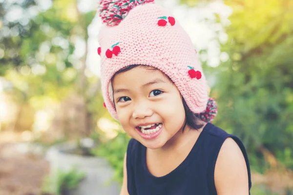 Mor çiçek alan güneş gün arasında duran küçük şirin Asyalı kız. Doğa ile zevk özgürlük.