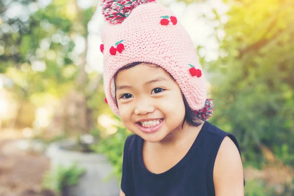 Mor çiçek alan güneş gün arasında duran küçük şirin Asyalı kız. Doğa ile zevk özgürlük.