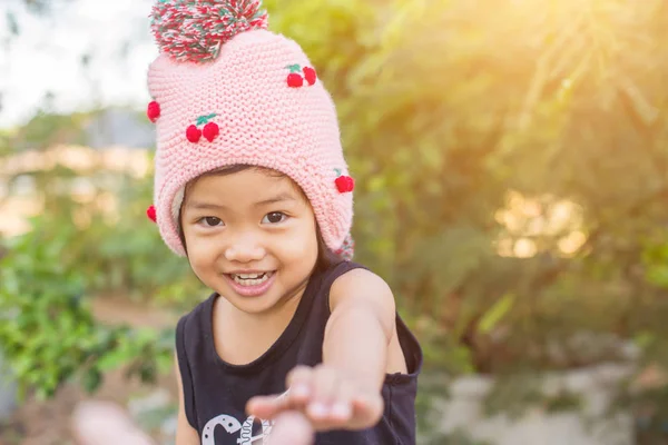 Mor çiçek alan güneş gün arasında duran küçük şirin Asyalı kız. Doğa ile zevk özgürlük.