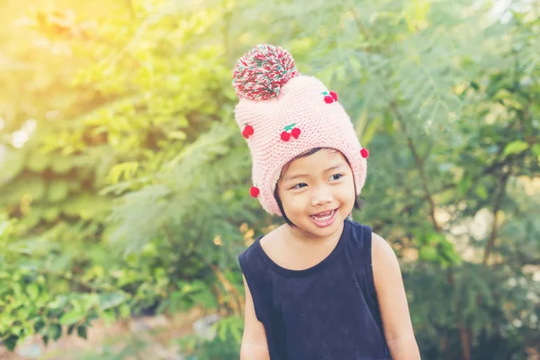 Mor çiçek alan güneş gün arasında duran küçük şirin Asyalı kız. Doğa ile zevk özgürlük.