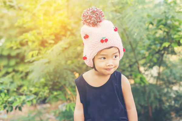 Mor çiçek alan güneş gün arasında duran küçük şirin Asyalı kız. Doğa ile zevk özgürlük.