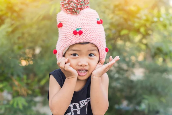 Mor çiçek alan güneş gün arasında duran küçük şirin Asyalı kız. Doğa ile zevk özgürlük.