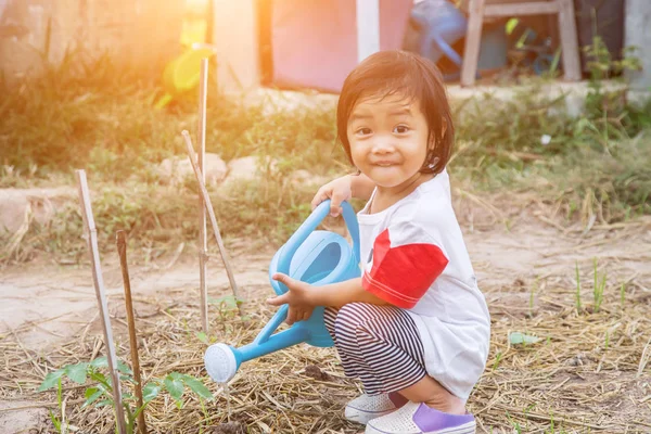 Küçük kız ağaç sulama pot ile sulama