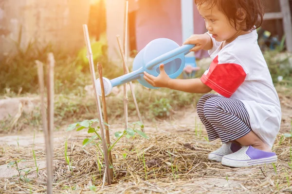 Küçük kız ağaç sulama pot ile sulama