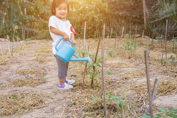 Küçük kız ağaç sulama pot ile sulama