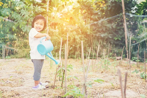 Küçük kız ağaç sulama pot ile sulama