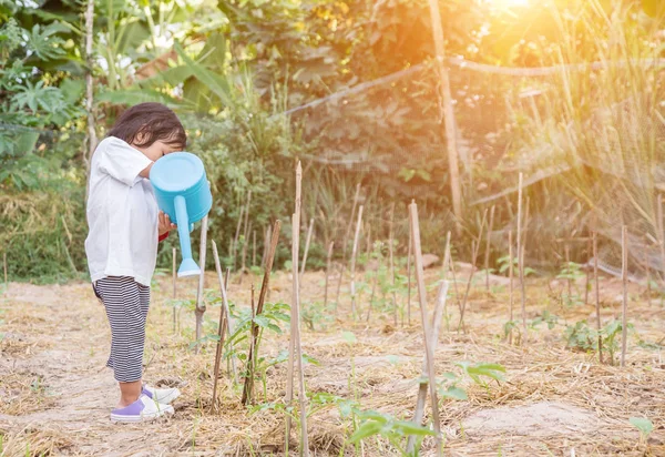 Küçük kız ağaç sulama pot ile sulama