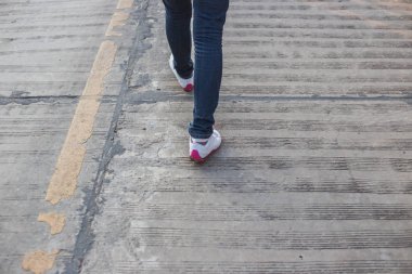 Kadın kot pantolon ve ayakkabı güneş ışığı ile yürüyüş