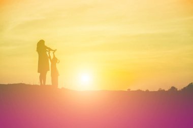 Anne gün batımında kızını gölgelerden çıkardı..