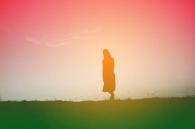 tek başına duran genç bir kadın silüeti