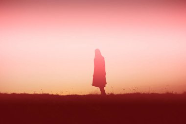 tek başına duran genç bir kadın silüeti