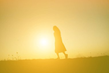 tek başına duran genç bir kadın silüeti