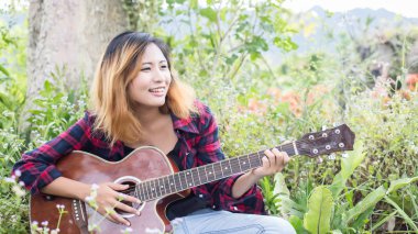 Genç kadının el iskambil gitar. Açık havada