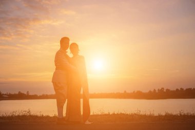 Birbirine bakan iki kızın silueti el ele tutuşuyor.