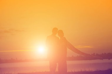 Birbirine bakan iki kızın silueti el ele tutuşuyor.