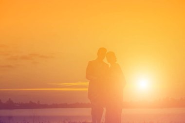 Birbirine bakan iki kızın silueti el ele tutuşuyor.