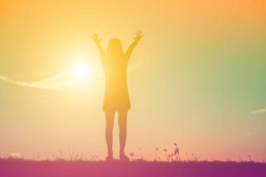 Güzel bir arka plan için dua eden bir kadın silueti.