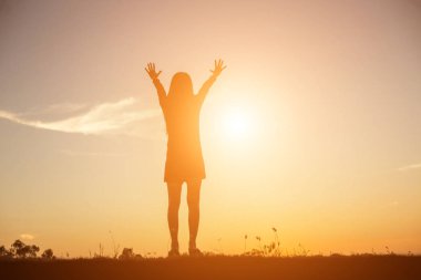 Güzel bir arka plan için dua eden bir kadın silueti.