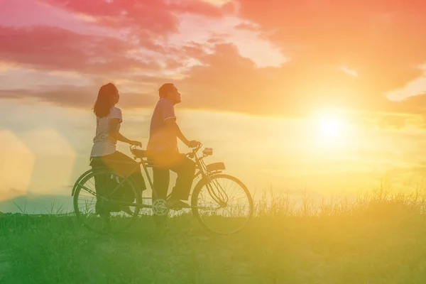 自転車の愛幸せな時間で甘いの若いカップルのシルエット — ストック写真