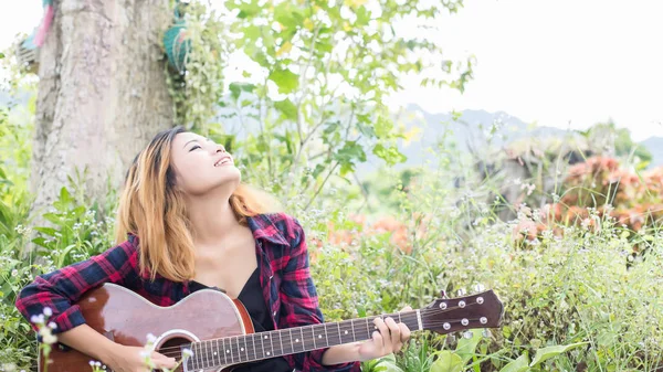 Genç kadının el iskambil gitar. Açık havada
