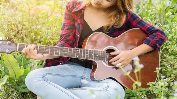 Genç kadının el iskambil gitar. Açık havada