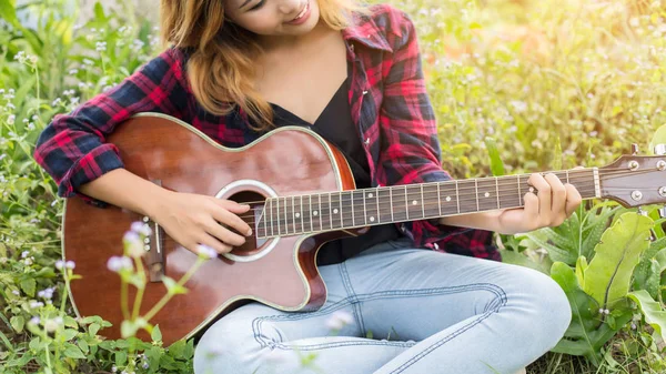 Genç kadının el iskambil gitar. Açık havada