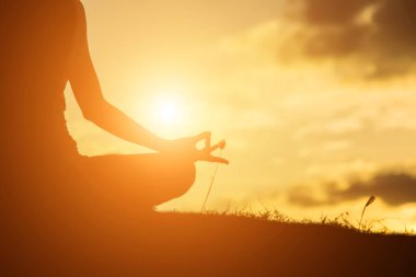 Güzel bir arka plan için dua eden bir kadın silueti.