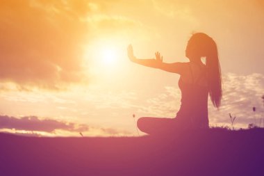 Güzel bir arka plan için dua eden bir kadın silueti.