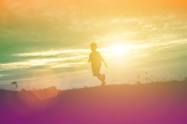 Çocuk siluet, çocuğun sevinç anlar. Doğa günbatımı