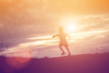 Çocuk siluet, çocuğun sevinç anlar. Doğa günbatımı