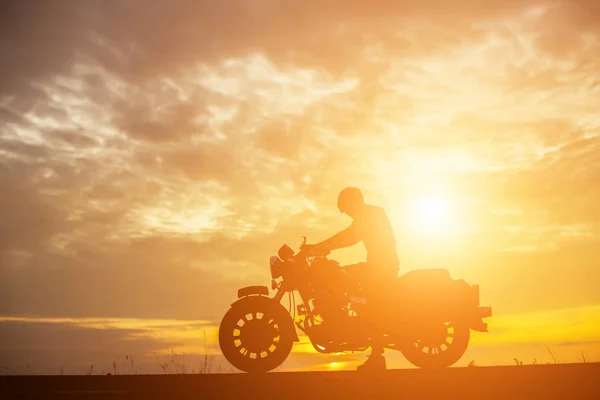 Adam motorcu günbatımı üzerinde 