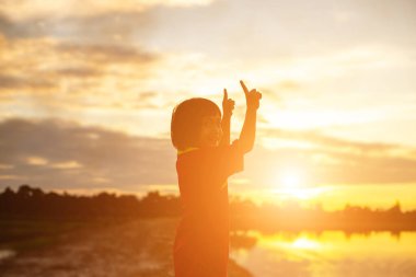 Çocuk siluet, çocuğun sevinç anlar. Doğa günbatımı