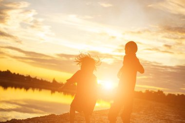 Çocuk siluet, çocuğun sevinç anlar. Doğa günbatımı